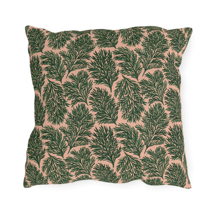 Dark green pine sprigs on blush peach outdoor pillow