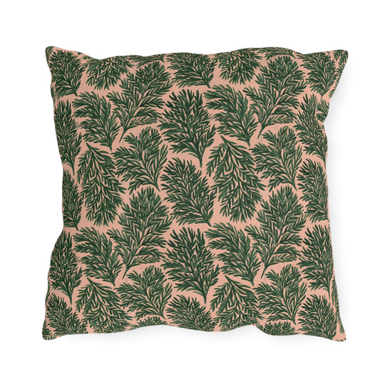 Dark green pine sprigs on blush peach outdoor pillow