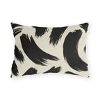 Black and cream outdoor lumbar pillow with loose abstract black brush strokes