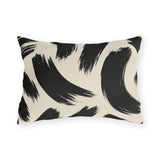 Black and cream outdoor lumbar pillow with loose abstract black brush strokes