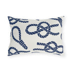 Nautical outdoor lumbar pillow with navy sailor rope knots, loops and coils on warm white