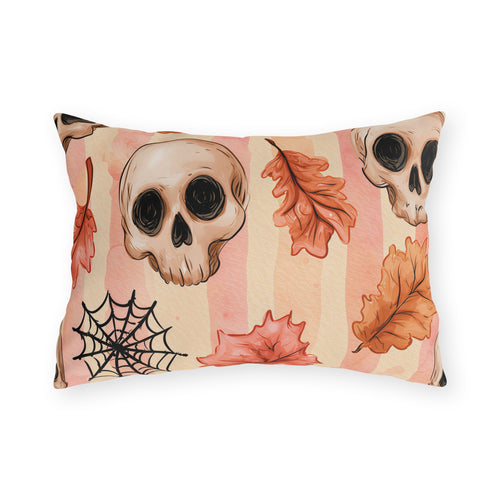Halloween outdoor lumbar pillow with watercolor skulls, autumn leaves and a spider web on pink and peach stripes