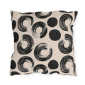 Black brush rings and solid dots on an oatmeal outdoor pillow