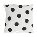 Black and white polka dot outdoor pillow with large hand-painted charcoal dots on warm white