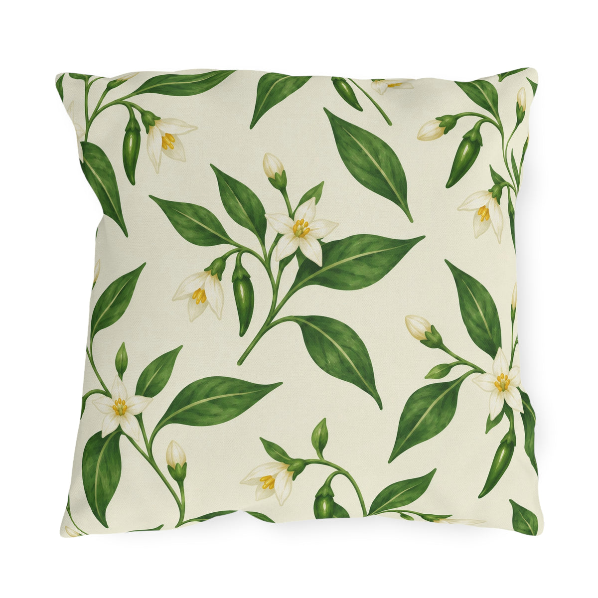 White pepper blossoms, green leaves and small chilies on a cream outdoor pillow