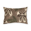 Cream and chocolate bows with spruce sprigs on a warm brown outdoor lumbar pillow