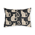 Cream folk art cats on a near-black outdoor lumbar pillow, worn block print