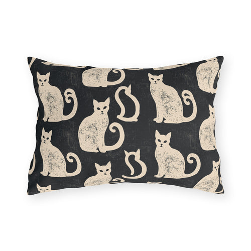 Cream folk art cats on a near-black outdoor lumbar pillow, worn block print