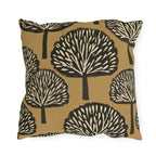 Black and cream block print trees on a warm ochre outdoor pillow