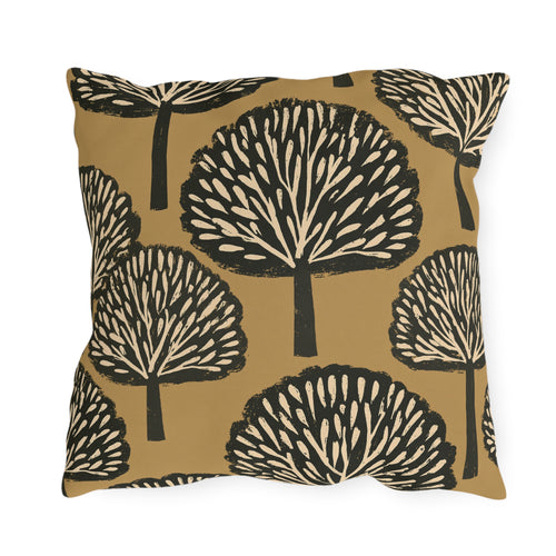 Black and cream block print trees on a warm ochre outdoor pillow