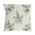 Green outdoor pillow with sage green eucalyptus sprigs tied with ribbon bows on cream