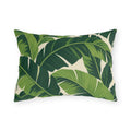 Tropical outdoor lumbar pillow with large overlapping fresh and deep green banana leaves on cream