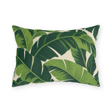 Tropical outdoor lumbar pillow with large overlapping fresh and deep green banana leaves on cream