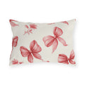 Pink outdoor lumbar pillow with hand-drawn rose pink ribbon bows and flower sprigs on cream