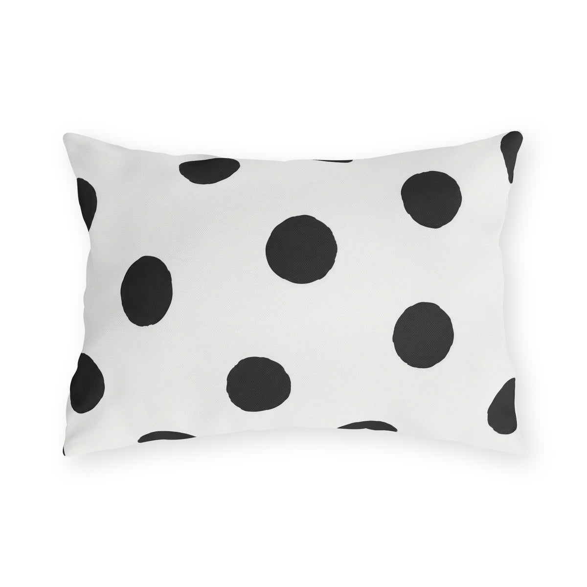 Black and white polka dot outdoor lumbar pillow with large hand-painted charcoal dots on warm white