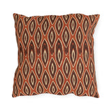 Nested ikat diamonds in charcoal and cream on a burnt rust outdoor pillow