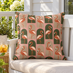 Blush flamingo arches outdoor pillow styled on a white porch bench
