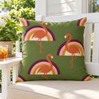 Olive retro rainbow flamingo outdoor pillow styled on a white porch bench