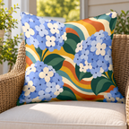 Blue groovy hydrangea outdoor pillow on a rattan chair on a sunny porch