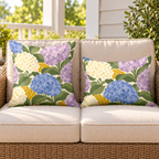 Periwinkle hydrangea outdoor pillow and outdoor lumbar pillow styled together as a set on a wicker loveseat