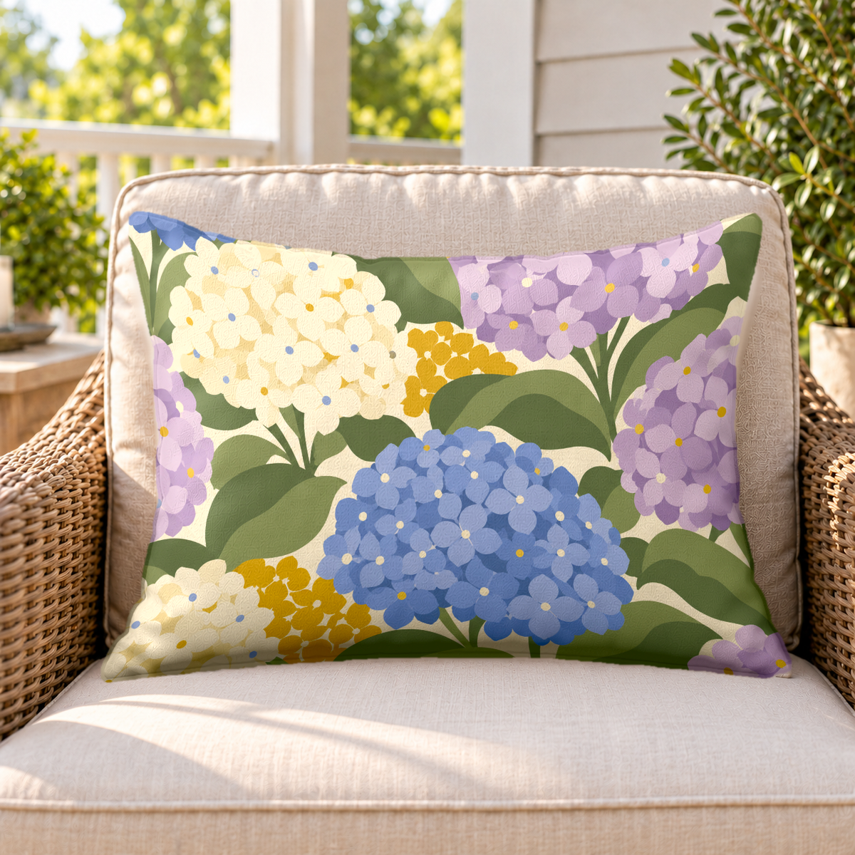 Periwinkle hydrangea outdoor lumbar pillow on a rattan chair on a sunny porch