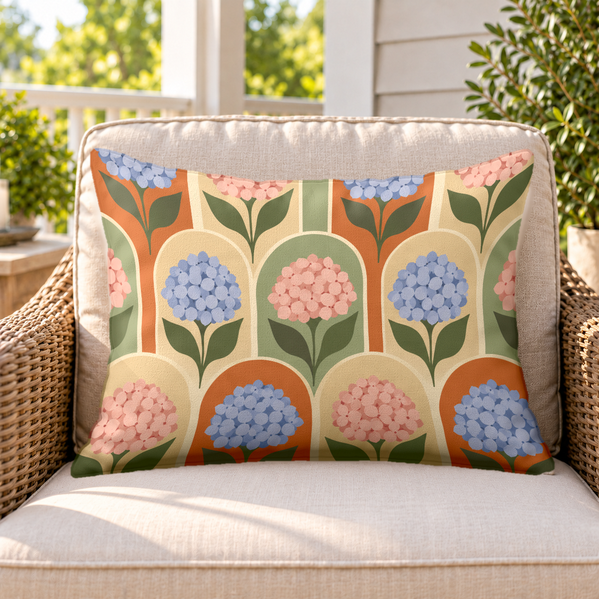 Terracotta hydrangea arch outdoor lumbar pillow on a rattan chair on a sunny porch