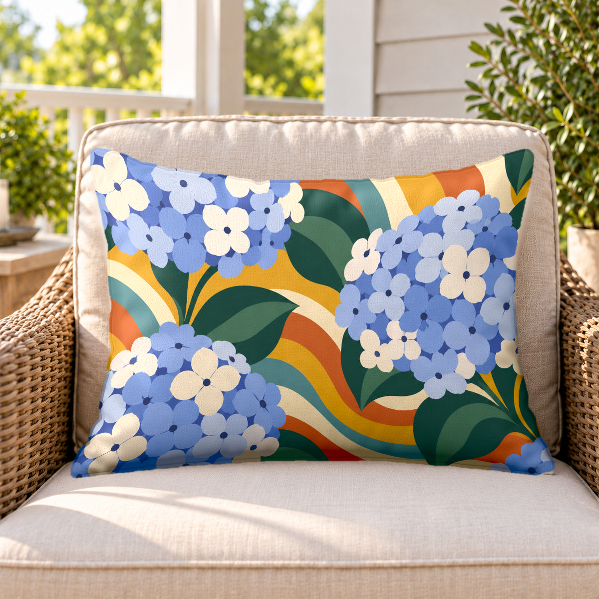 Blue groovy hydrangea outdoor lumbar pillow on a rattan chair on a sunny porch