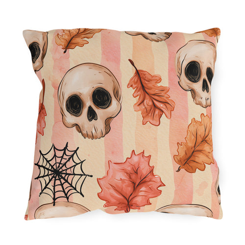 Halloween outdoor pillow with watercolor skulls, autumn leaves and a spider web on pink and peach stripes