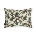 Ivory and sage ribbon bows on cedar sprigs with white berries on a cream outdoor lumbar pillow