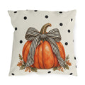 Orange pumpkin with a black and cream striped bow on a black polka dot outdoor pillow