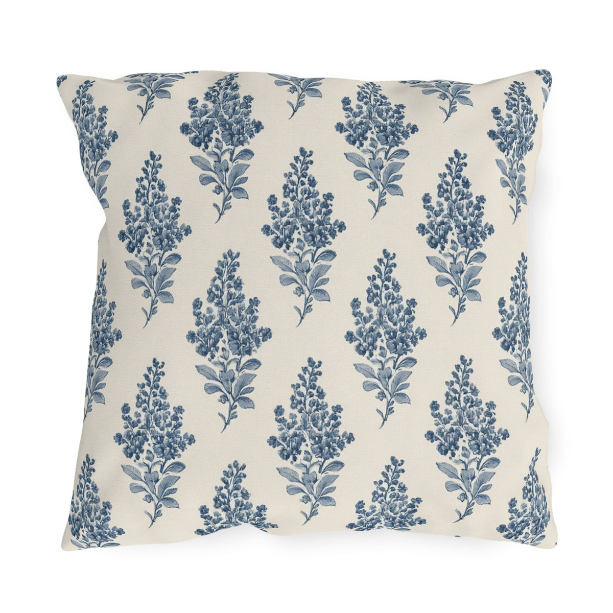 Blue engraved blossom sprigs on a cream outdoor pillow