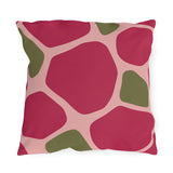 Modern outdoor pillow with large raspberry pink and olive green pebble shapes on blush