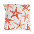 Coastal outdoor pillow with tossed coral and peach starfish and sandy dots on white
