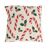 Christmas outdoor pillow with red and white candy canes and holly on cream