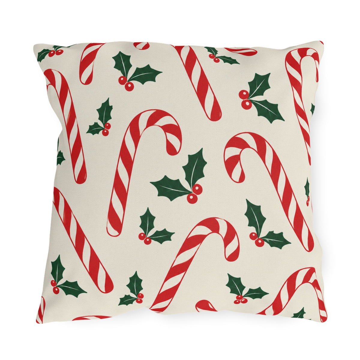 Christmas outdoor pillow with red and white candy canes and holly on cream