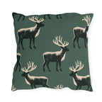 Black and cream block print stags on a deep forest green outdoor pillow