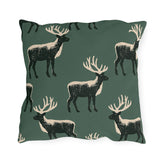 Black and cream block print stags on a deep forest green outdoor pillow