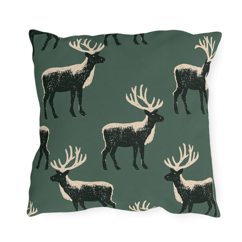 Black and cream block print stags on a deep forest green outdoor pillow