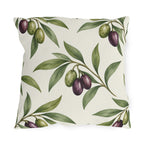 Green and purple olives on branches over a cream outdoor pillow