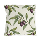 Green and purple olives on branches over a cream outdoor pillow