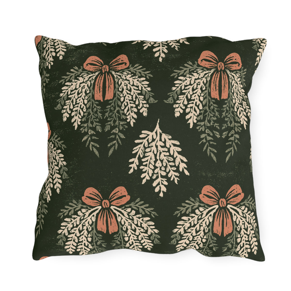 Cream cedar fronds and terracotta bows on a near-black forest green outdoor pillow