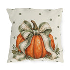 Orange pumpkin with a sage striped bow and oak leaves on a cream polka dot outdoor pillow