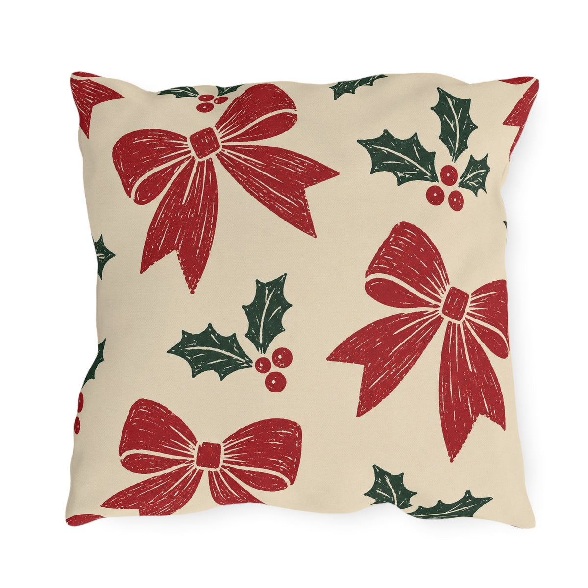 Red bows and green holly block printed on a cream outdoor pillow
