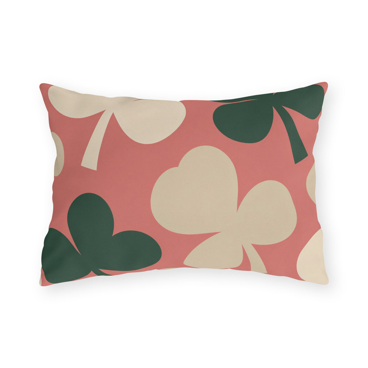Modern outdoor lumbar pillow with oversized cream and forest green clover leaves on coral pink