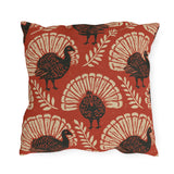 Block print turkeys and cream leaf sprigs on a brick red outdoor pillow