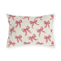 Rose pink engraved ribbon bows scattered on cream outdoor lumbar pillow