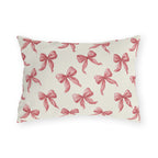 Rose pink engraved ribbon bows scattered on cream outdoor lumbar pillow