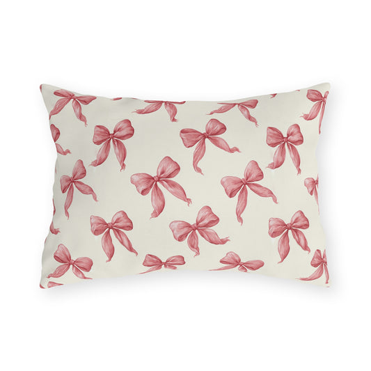 Rose pink engraved ribbon bows scattered on cream outdoor lumbar pillow