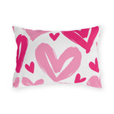Hot pink outdoor lumbar pillow with large painted hearts in hot pink and soft pink on white