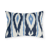 Navy and white ikat stripe outdoor lumbar pillow with feathered navy bands and light blue accents